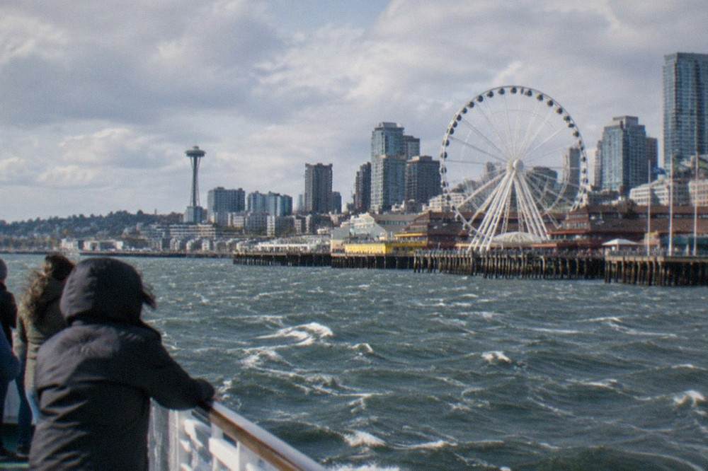 A sightseeing cruise boat passing the Seattle Great Wheel on the central waterfront
