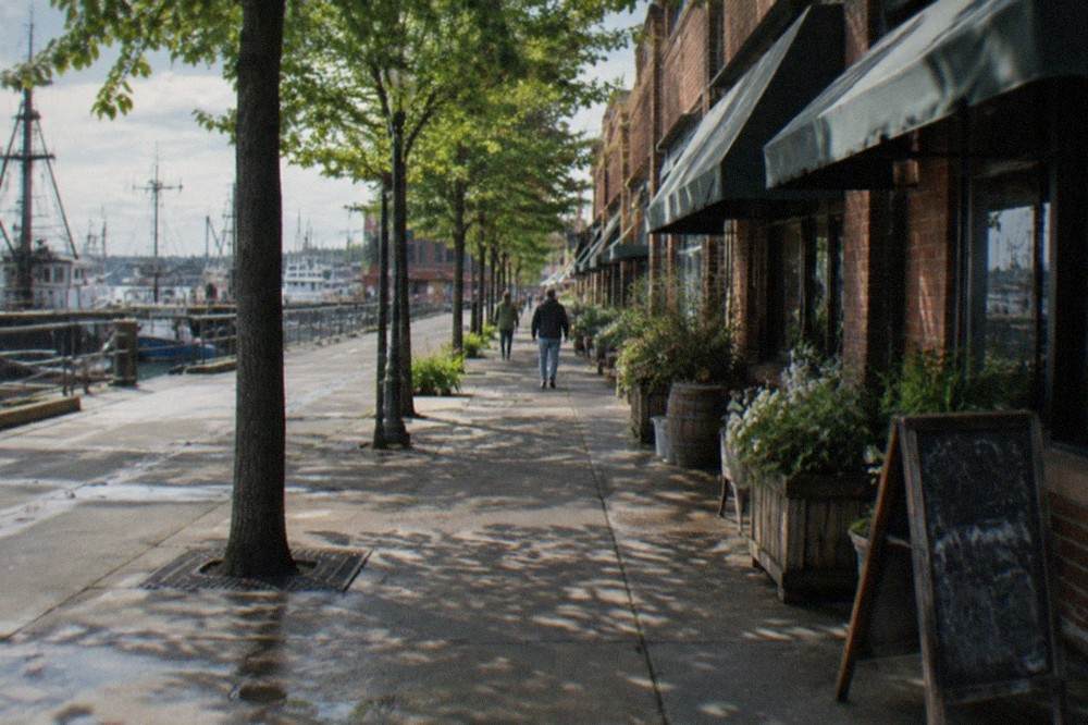 Brick storefronts along a quiet historic Ballard avenue with awnings and street trees