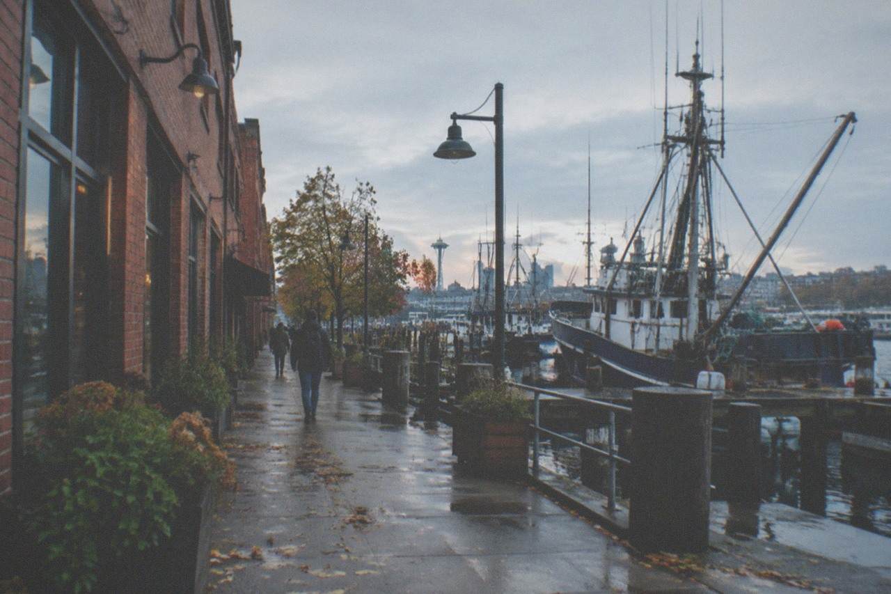 Historic Ballard main street with brick storefronts and a fishing vessel mast visible above the rooftops