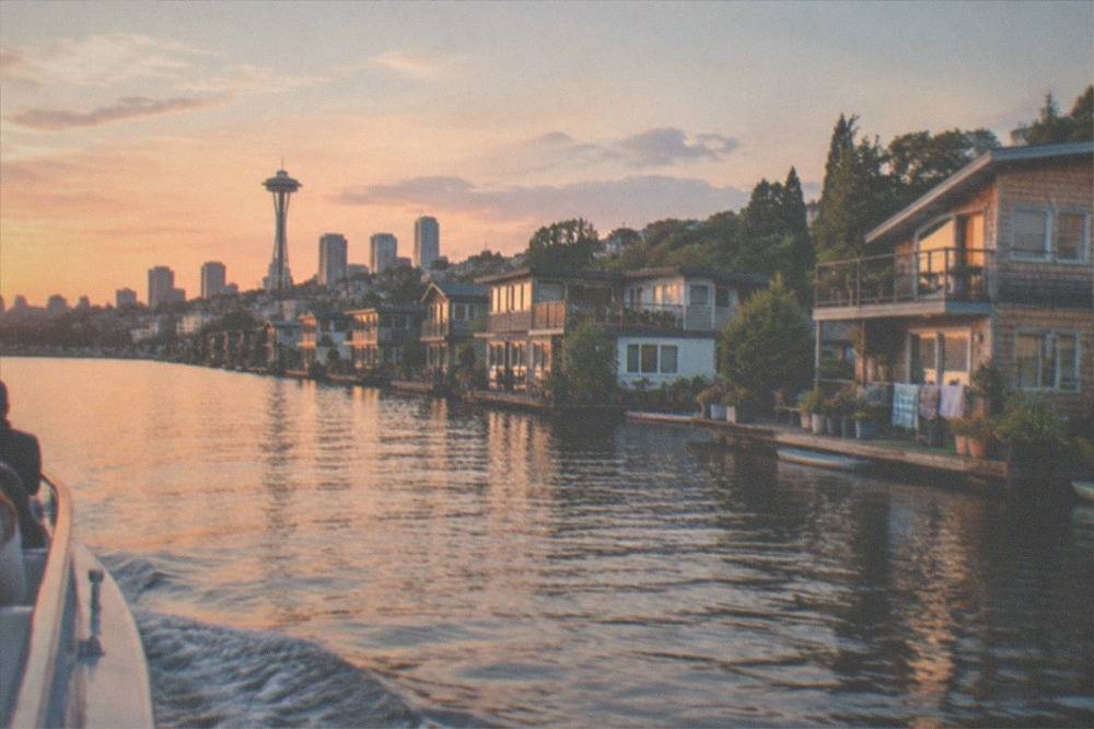 A tour boat cruising past rows of floating homes along a calm urban lake shoreline