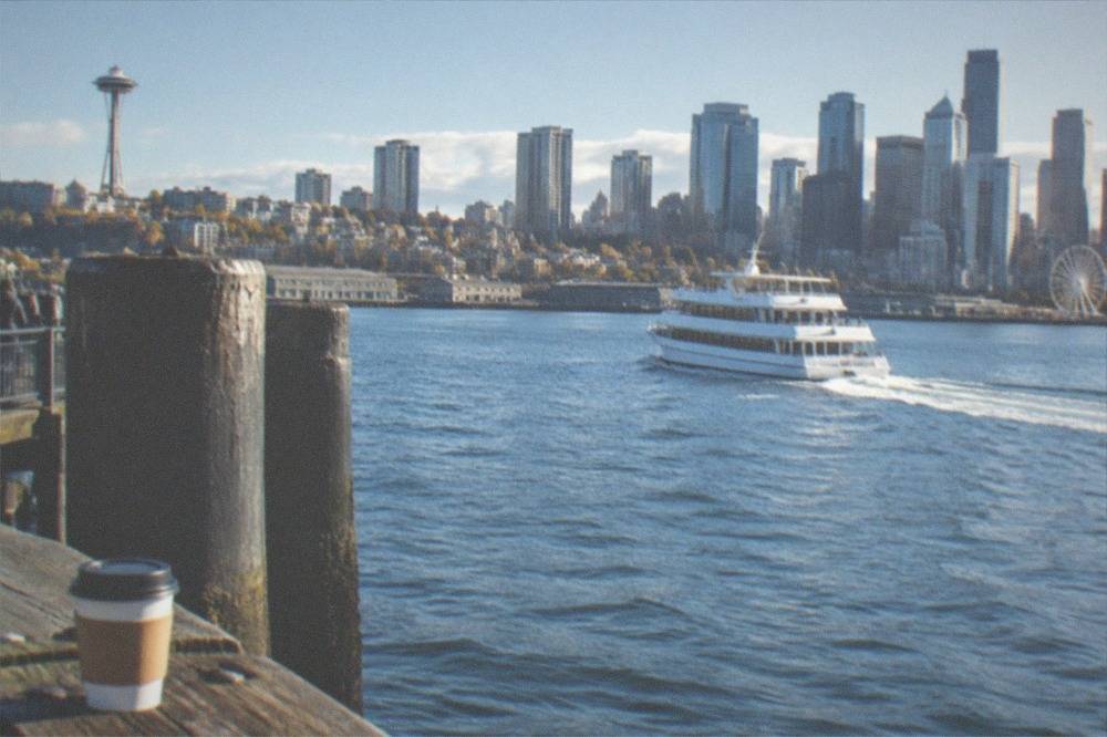 A passenger boat crossing Elliott Bay with the downtown skyline rising behind it