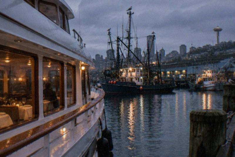 Evening tables set on a cruise boat as Seattle lights come on; the dinner-cruise category holds one option, a 2.5 hour experience from $143 per person by Waterways Cruises & Events with free cancellation on the listing.