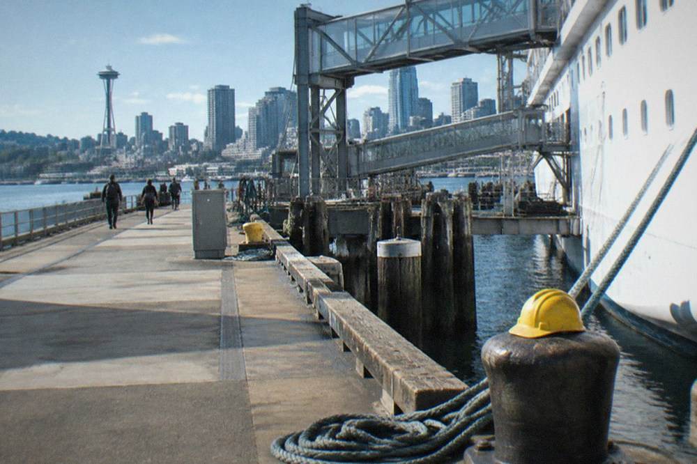 A cruise terminal pier on Elliott Bay with gangways and a moored ship on a clear day.