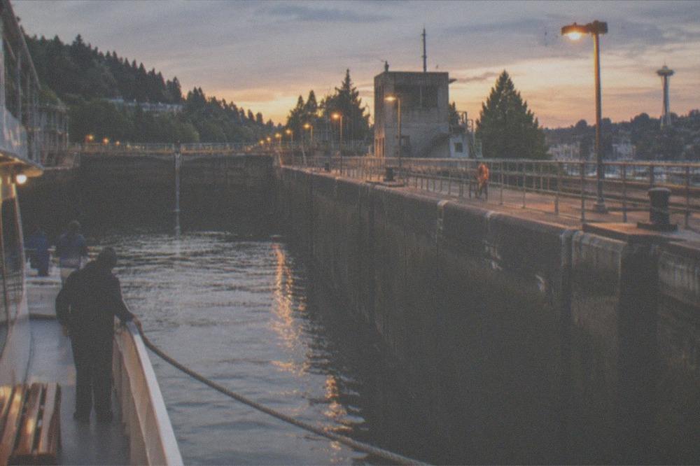 A passenger boat tied off inside the lock chamber with lines ashore as the water level changes