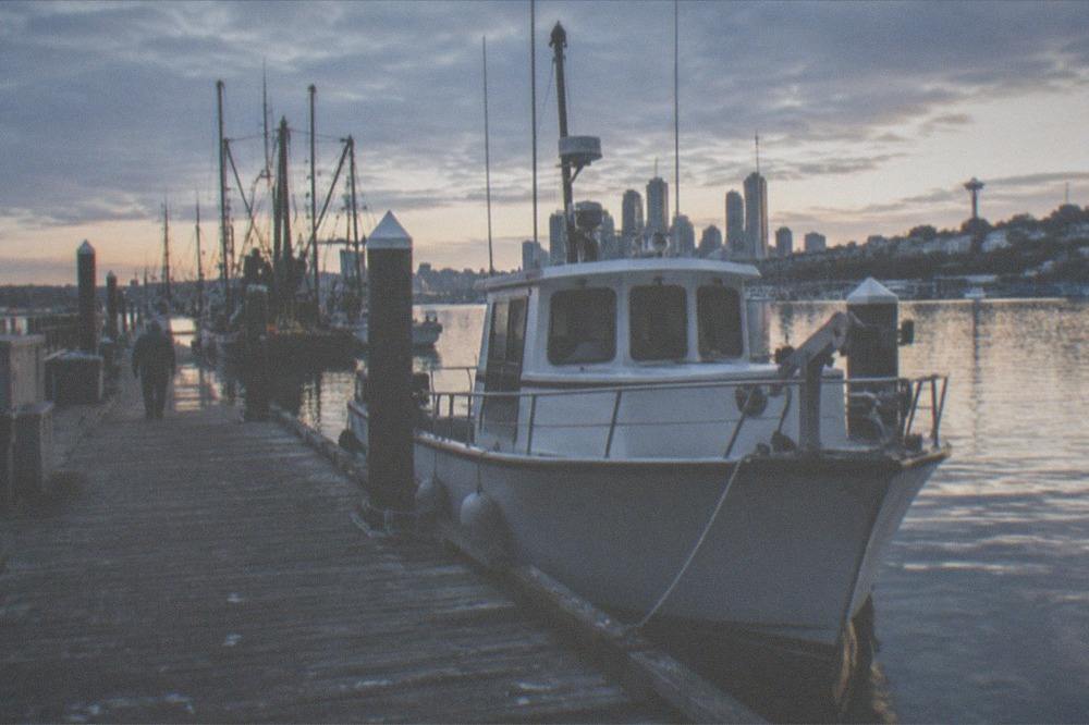A dock on Lake Union with a charter boat moored beside a wooden walkway