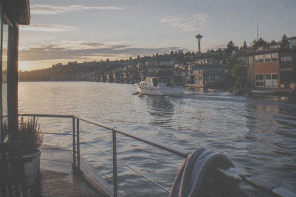 A chartered boat gliding past houseboats on Lake Union in late afternoon light