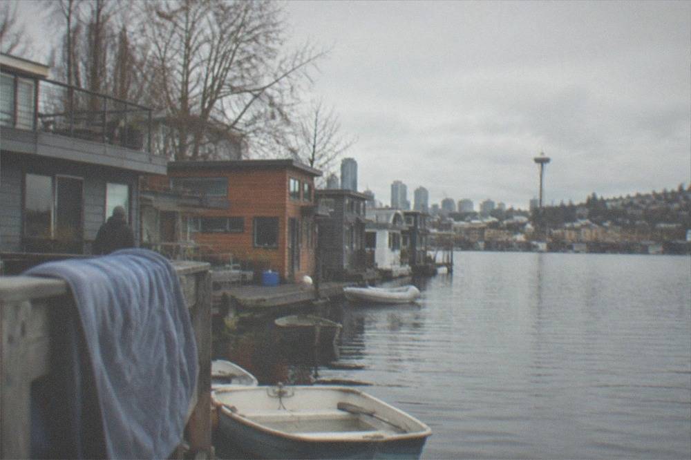 Houseboats moored along the shoreline of Lake Union under an overcast sky