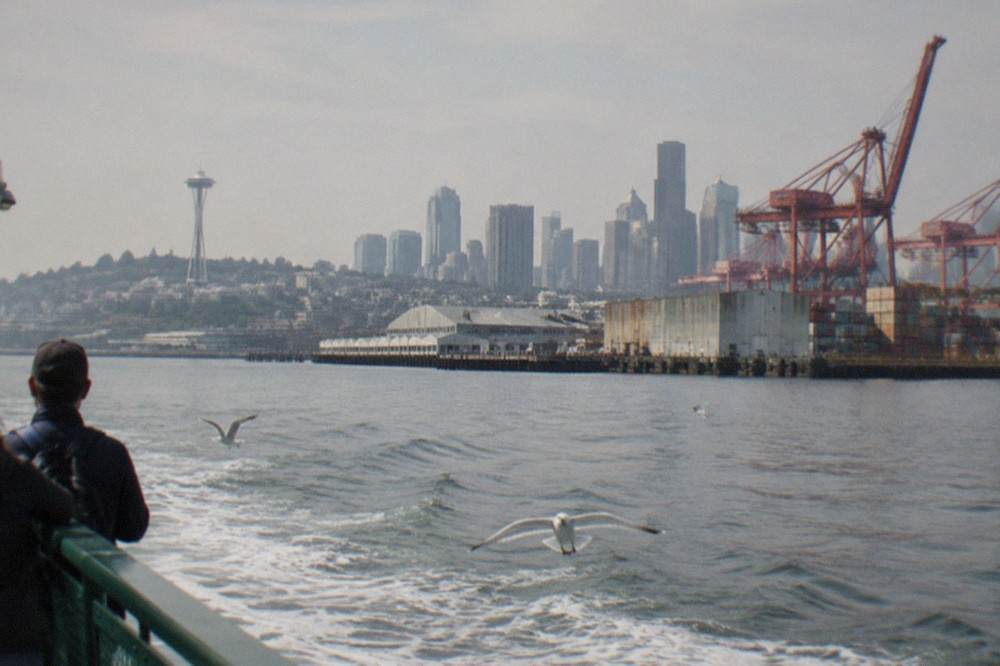 A narrated sightseeing boat on Elliott Bay with cranes and container terminals along the shore