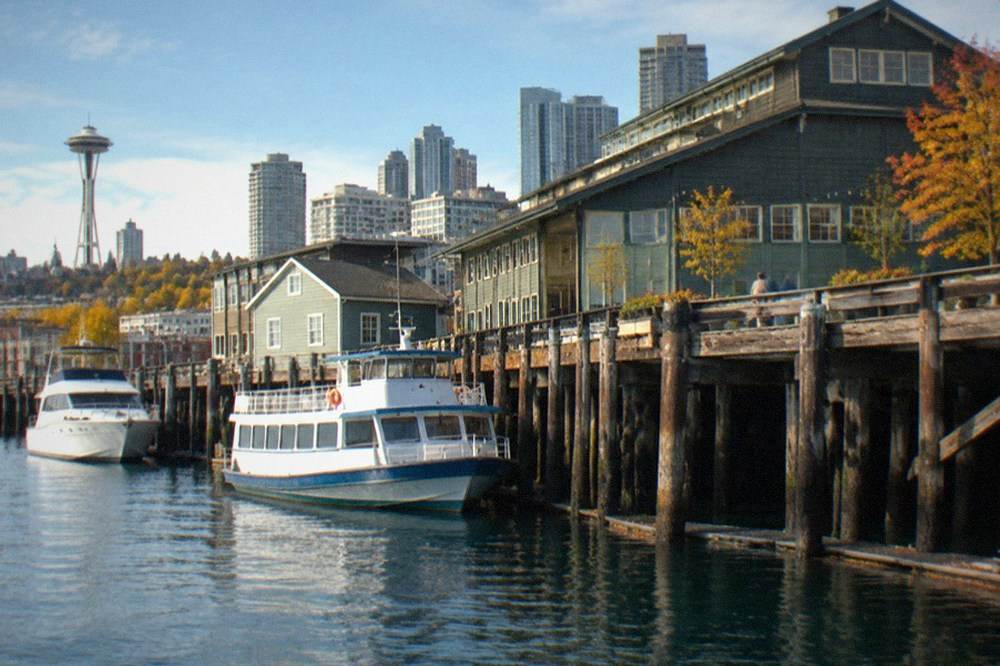 The wooden pier buildings of the central Seattle waterfront seen from the water on a clear day