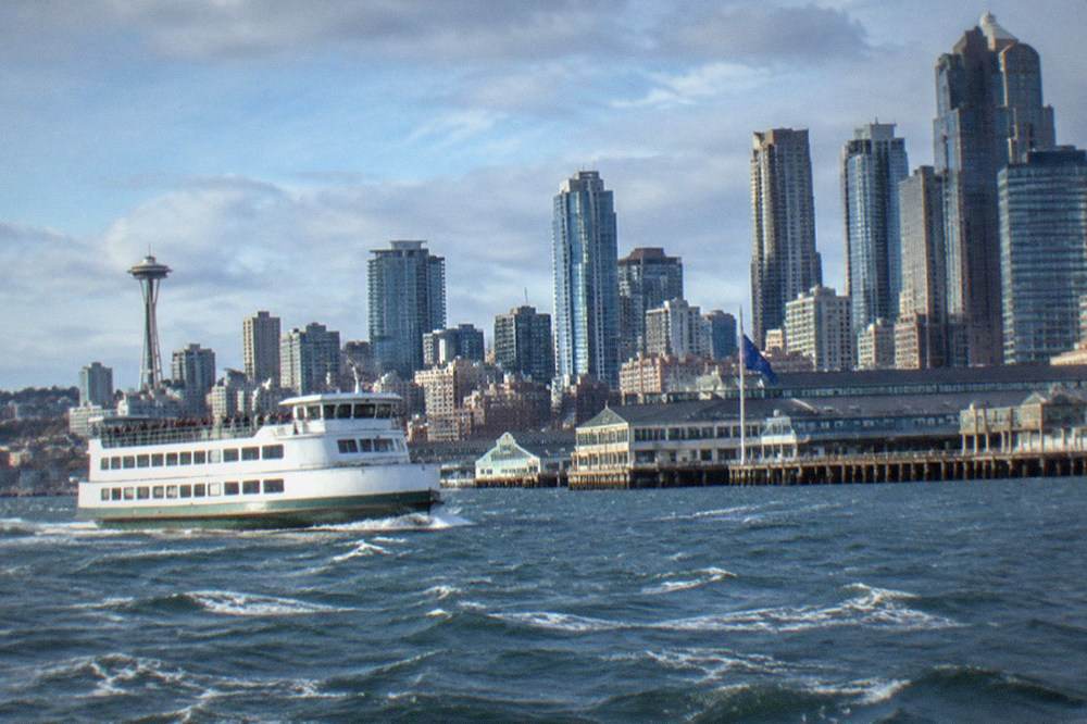 A narrated harbor cruise boat passing the downtown Seattle skyline on Elliott Bay