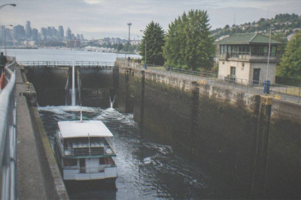 A tour boat inside the Ballard Locks chamber as water level changes around it
