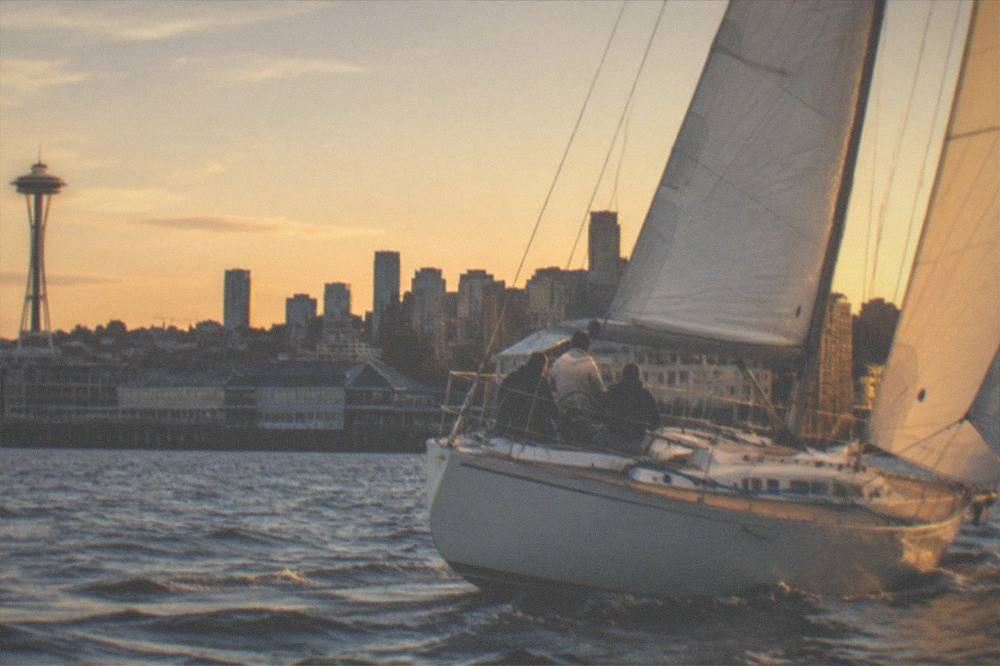 sailing yacht heeling under full sail on Puget Sound in late evening light