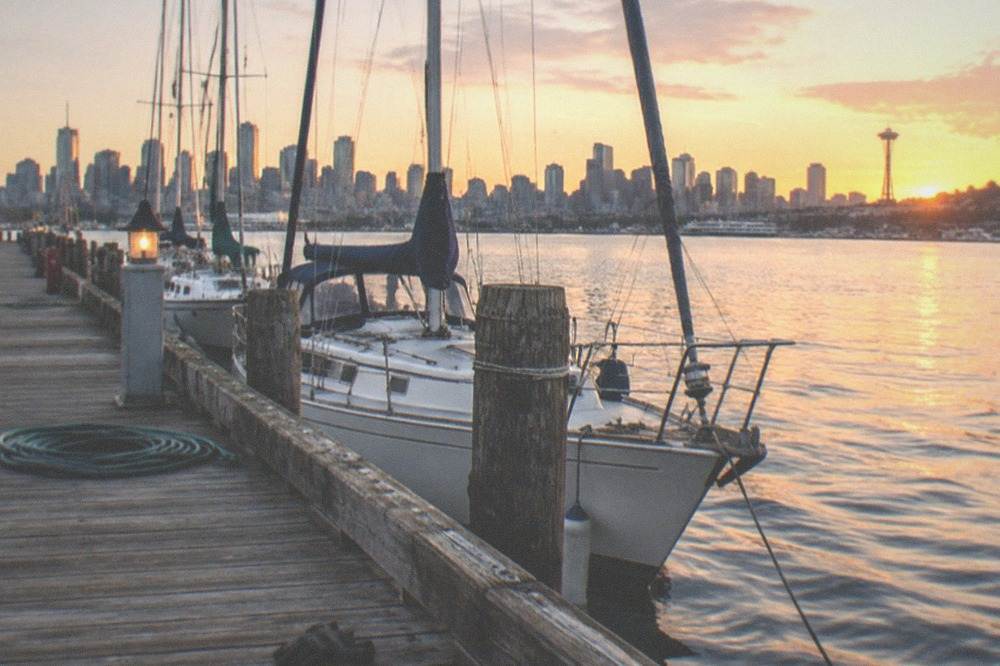 wooden docks and moored sailboats on the Seattle waterfront in warm evening light