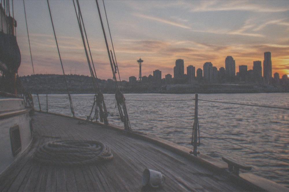 couple-free deck of a sailing cruise with the Seattle skyline glowing at sunset