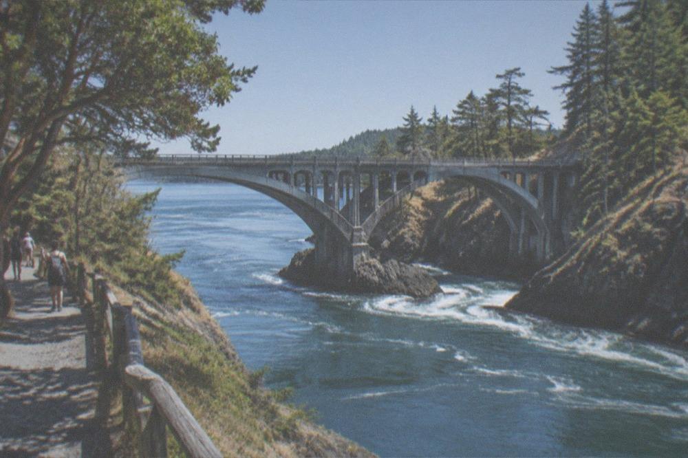 A tall bridge spanning the narrow turbulent channel of Deception Pass